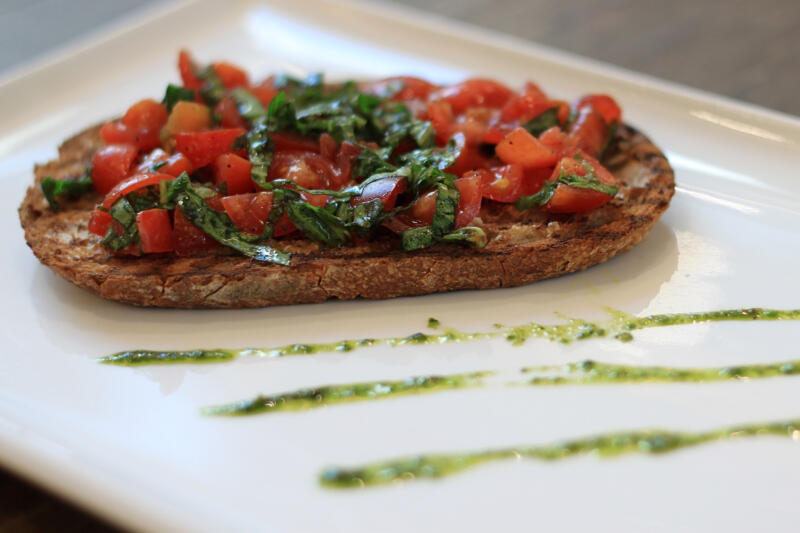 Bruschetta toast with tomatoes and pesto on a plate