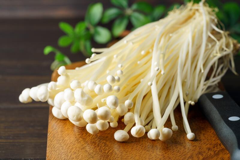 Butch of enoki mushrooms on a wooden table
