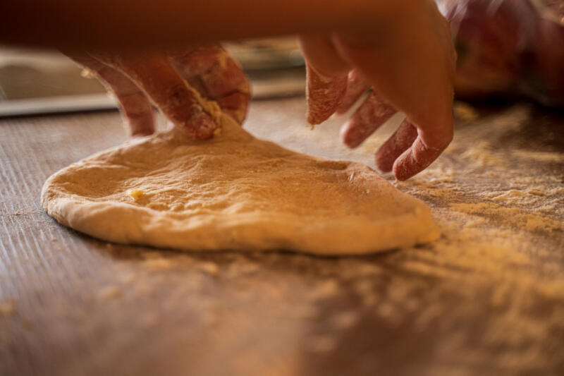 A cook kneading the dough for a pizza