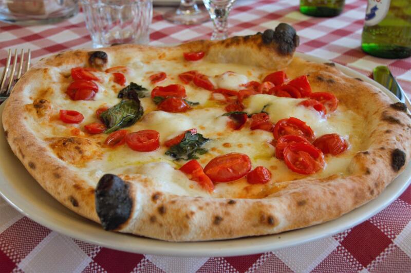 Neapolitan Margherita pizza on a traditionallly decorated table