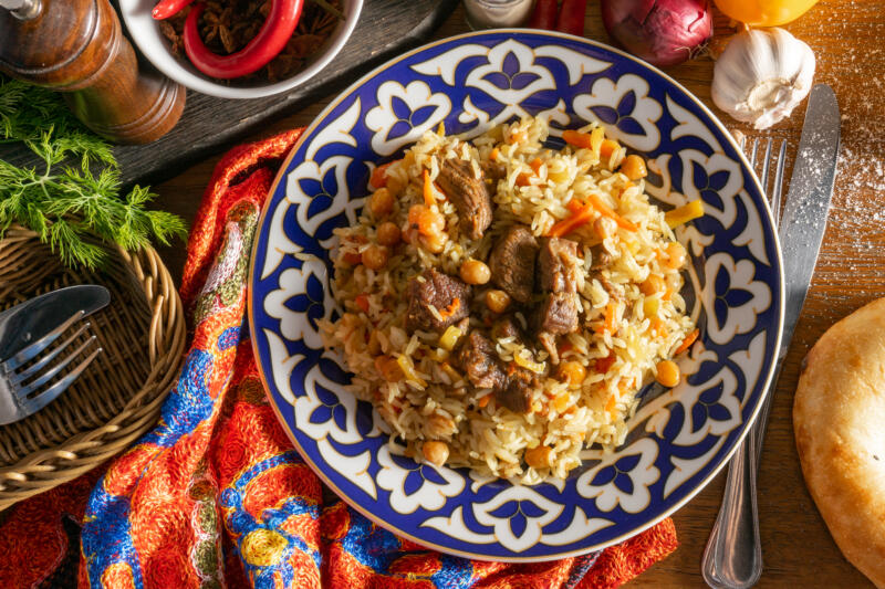 Lamb pilaf in a traditional plate on a decorated table