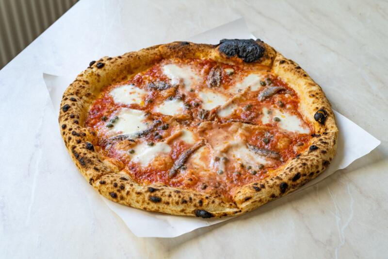 Neapolitan Anchovy pizza on the white table 