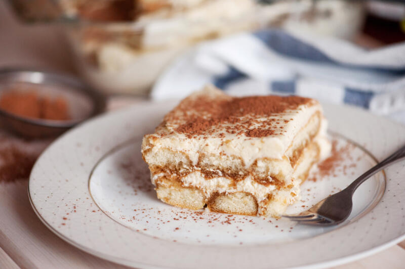 Homemade tiramisu cake slice in a white plate