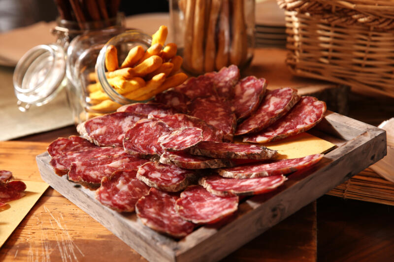 Sliced Italian salami with bread sticks on the table