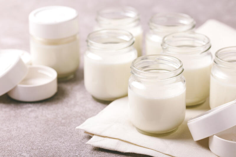 Homemade greek yogurt in glass jars on the gray stone table