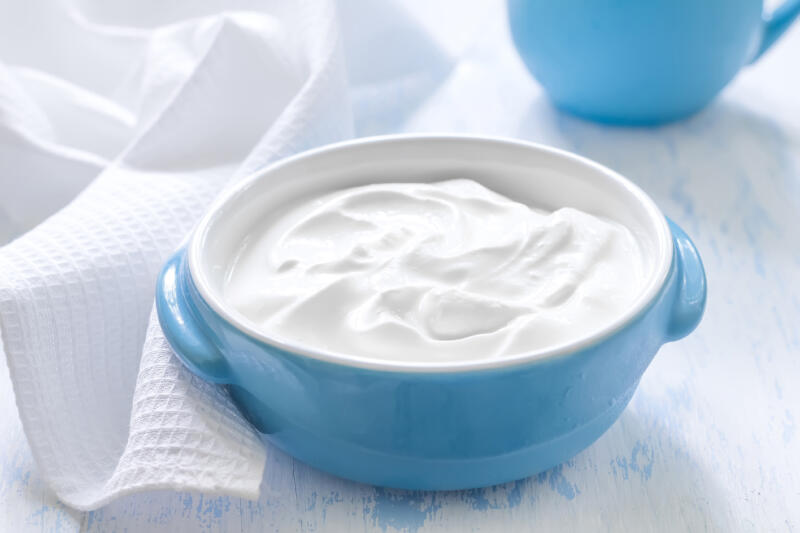 Bowl of yogurt on white table
