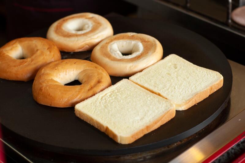 Bagel halfs and slices of bread on a grill 