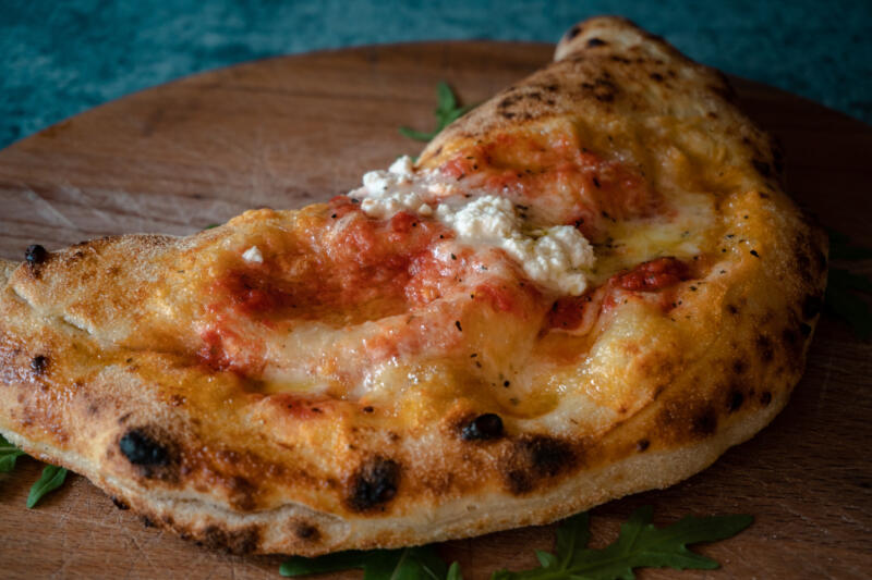 Calzone with Ricotta cheese and tomato sauce on a wooden board