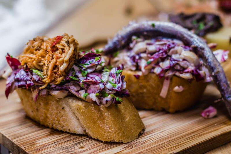 Cicchetti with red cabbage and anchovies on a board, Italian small appetizer