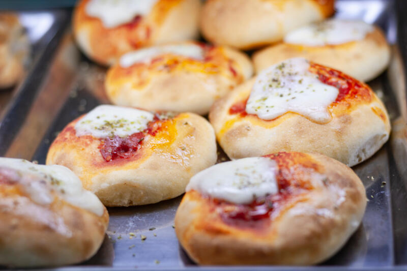 Mini pizzas or pizzette in a pan in a bakery shop