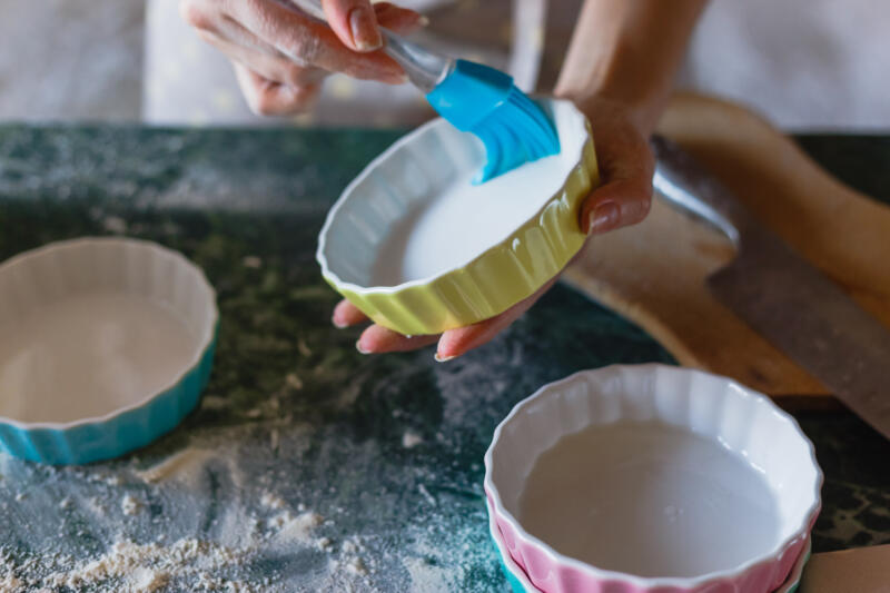 Woman greasing baking molds