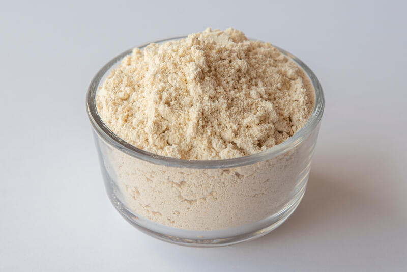 Oat flour in a bowl on white background