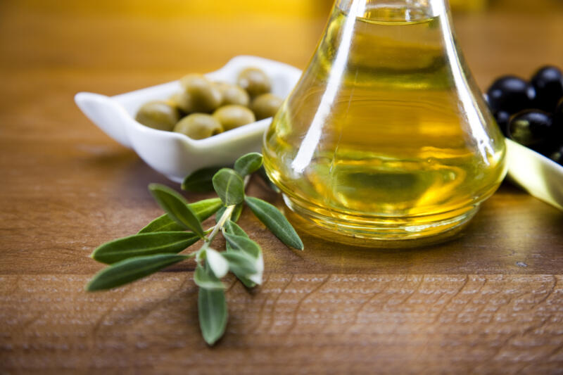 Olive oil and fresh olives on the table