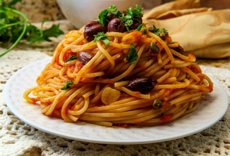 Delicious Italian spaghetti alla puttanesca with kalamata olives and capers