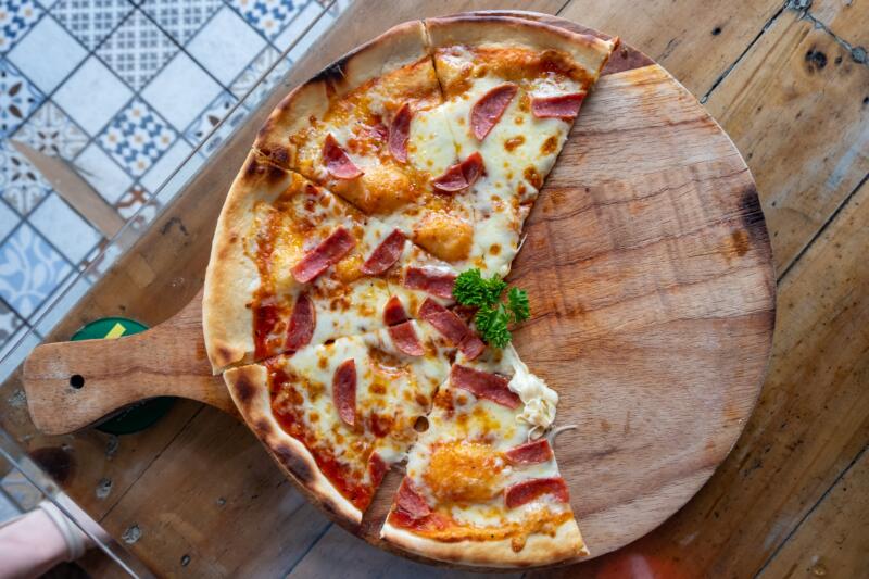 A half sheet of pepperoni pizza left on a kitchen table