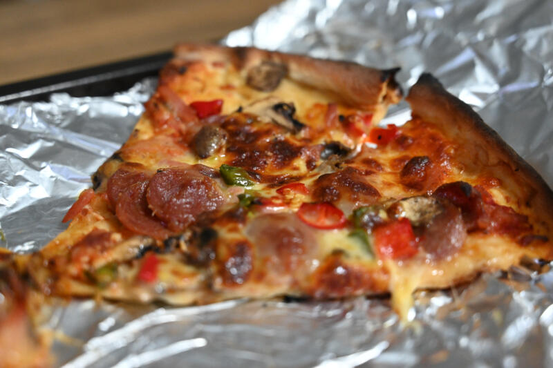 Reheating leftover pizza slices in the oven with aluminum foil and a baking sheet