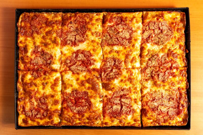 Rectangular Sicilian pizza in teglia with mozzarella cheese and tomato sauce