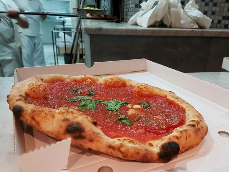 Marinara pizza in a paper box in a pizzeria
