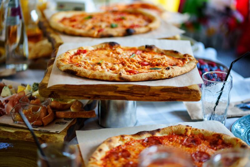 Several pizzas on a table full of food