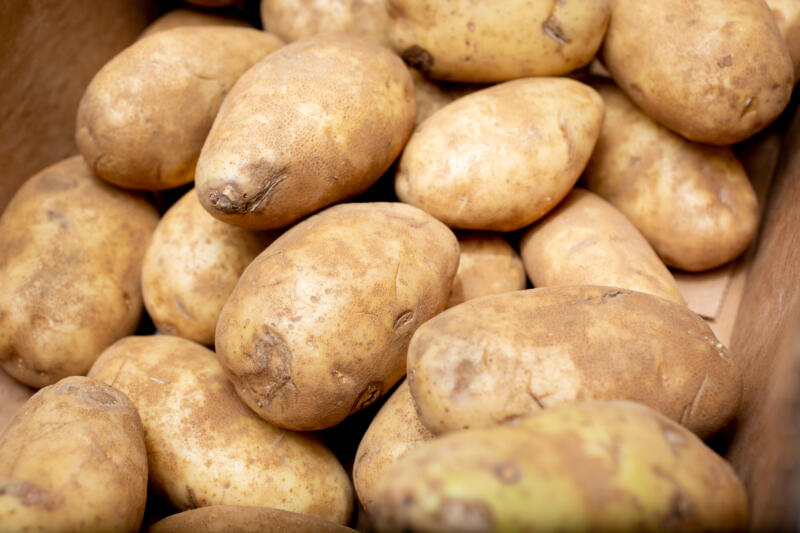 A view of a pile of russet potatoes inside a box