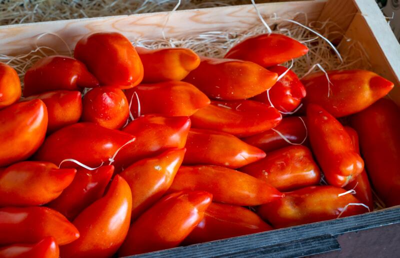 Long ripe San Marzano tomatoes in a wooden box