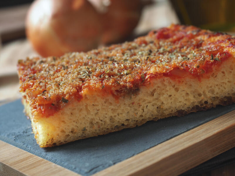 A slice of Sicilian sfincione on a table