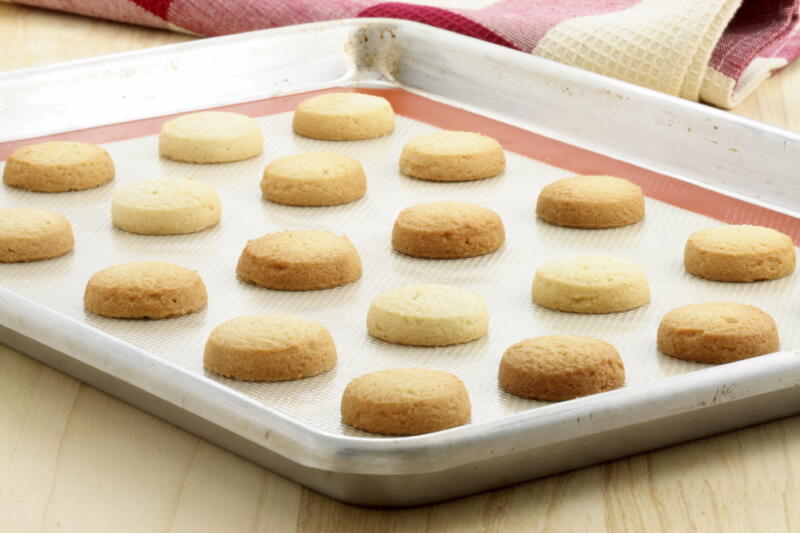 Fresh baked shortbread cookies on baking tray laid with a silicone mat