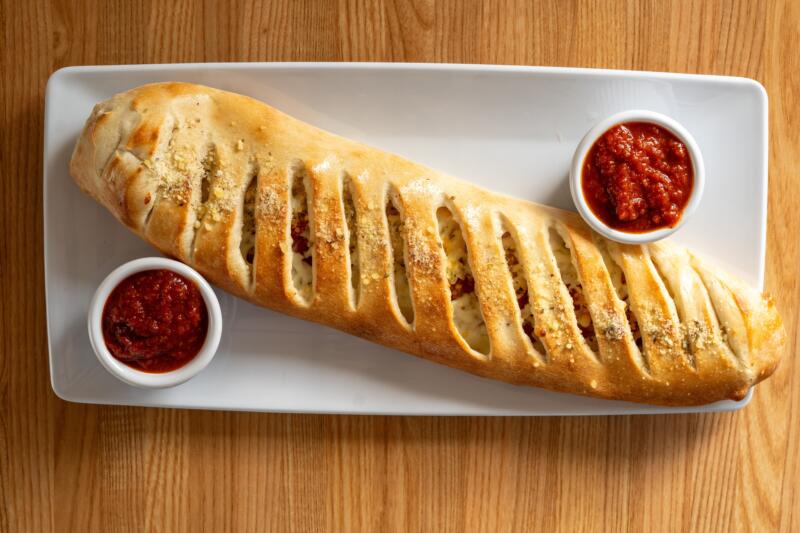 Stromboli served with marina sauce on a white plate