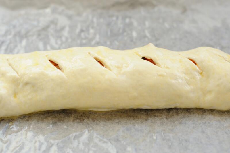 A freshly shaped cylinder of stromboli on a kitchen counter