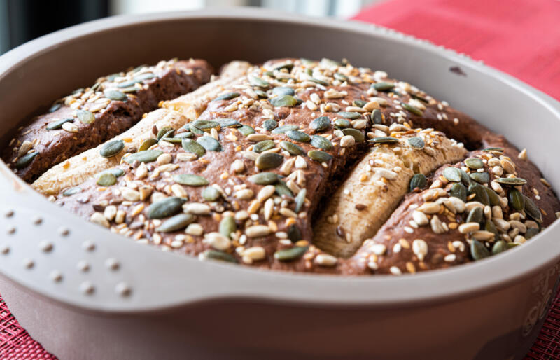 Homemade banana bread with sunflower and pumpkin seeds in a silicon baking form