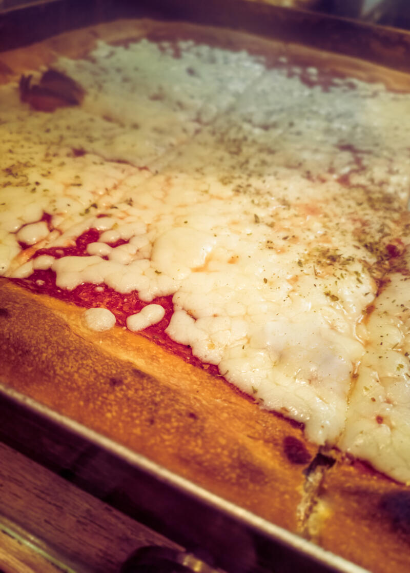 Traditional Sicilian pizza with tomato sauce and cheese in a pan