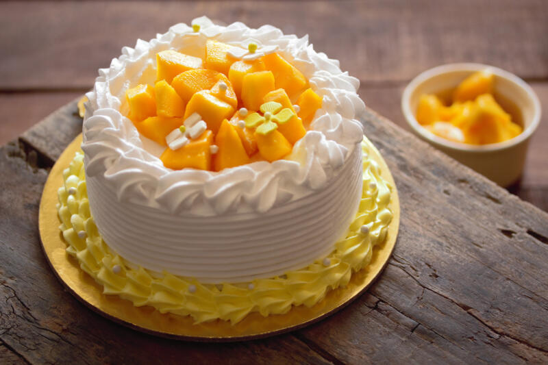 Mango cake frosted with whipped cream on a table