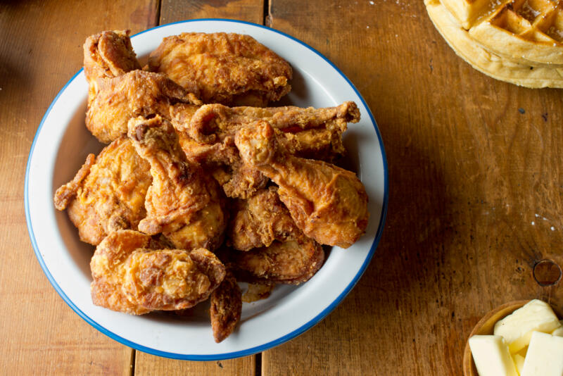 Fried crispy chicken in a plate on a wooden table