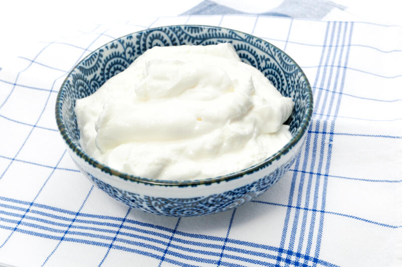 Greek yogurt in a bowl on a kitchen towel