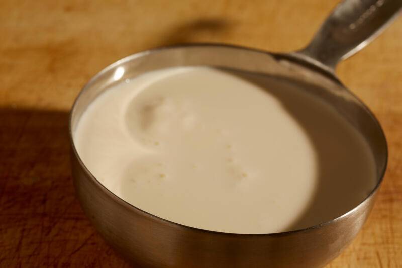 Heavy cream in a steel measuring cup