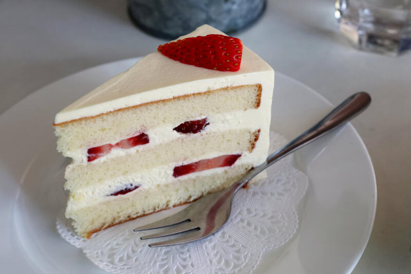 A slice of Japanese strawberry shortcake on a plate with a fork
