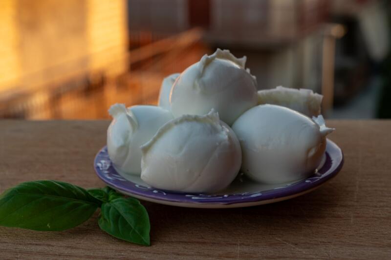 Several Mozzarella balls on a plate on a wooden surface