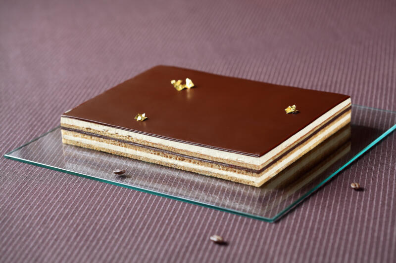 Gateau Opera cake on a table with coffee beans