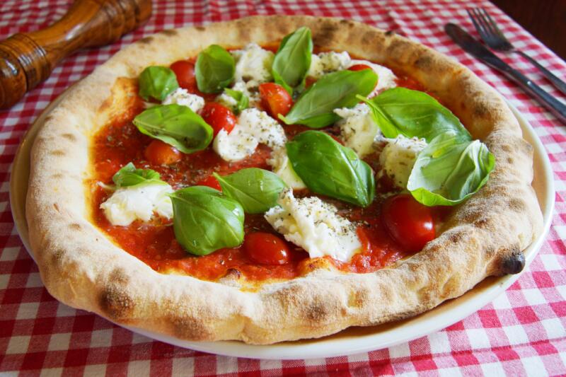 Margherita pizza with pieces di Mozzarella di Bufala on a plate served in a restaurant