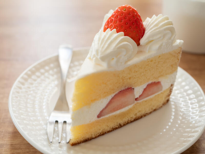 A slice of Japanese strawberry shortcake on a plate with a fork