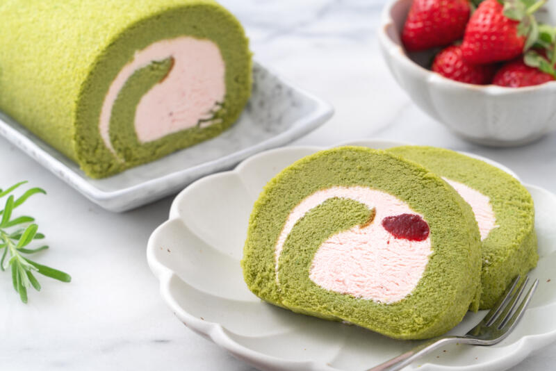 Matcha Swiss Roll Cake slices with strawberry icing cream on plates