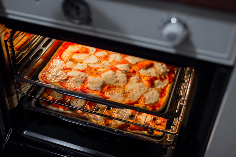 Homemade pizzas al teglia while baking in the oven