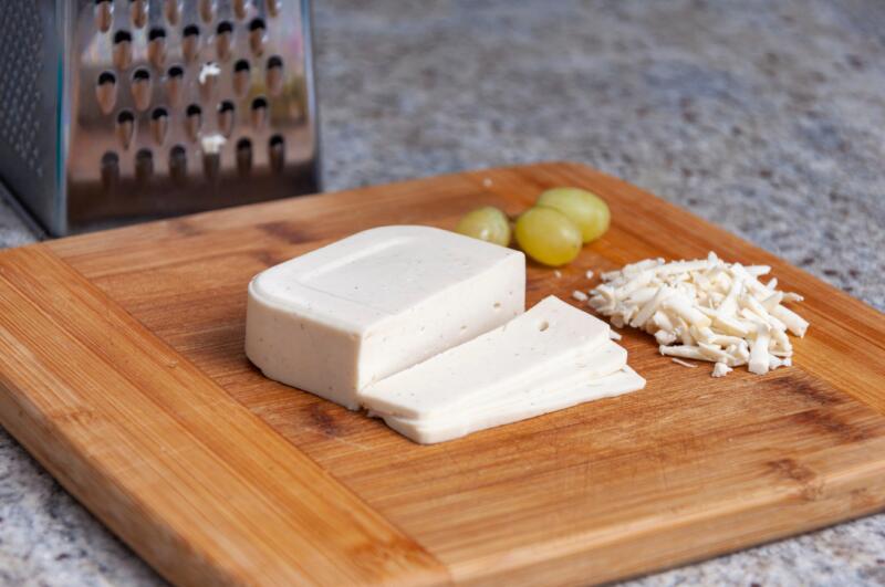 Vegan Mozzarella, grated and sliced on a cutting board