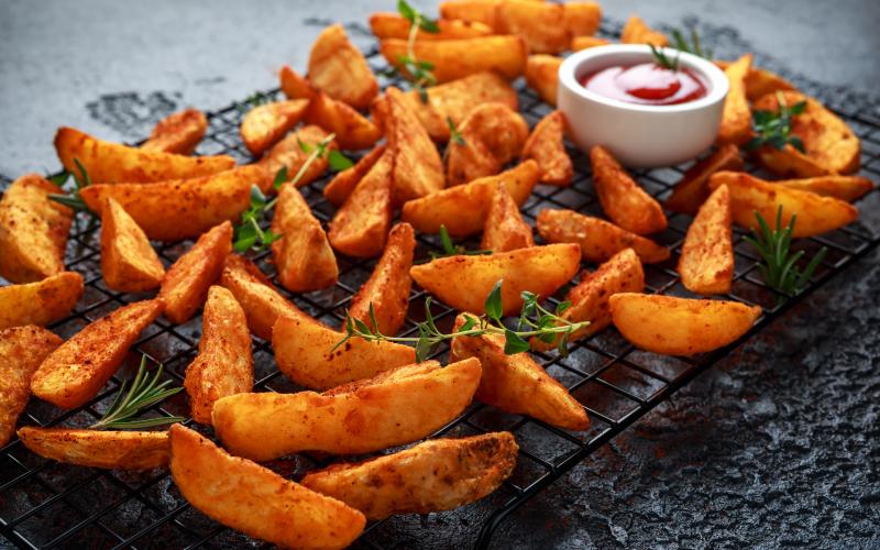 Paprika potato wedges fries chips chilling on a rack