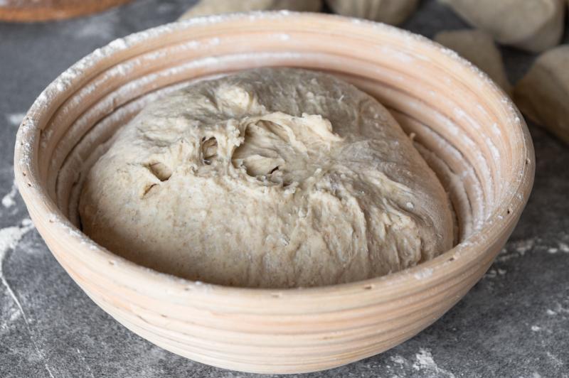 Proofing bread dough in a bowl on a kitchen counter