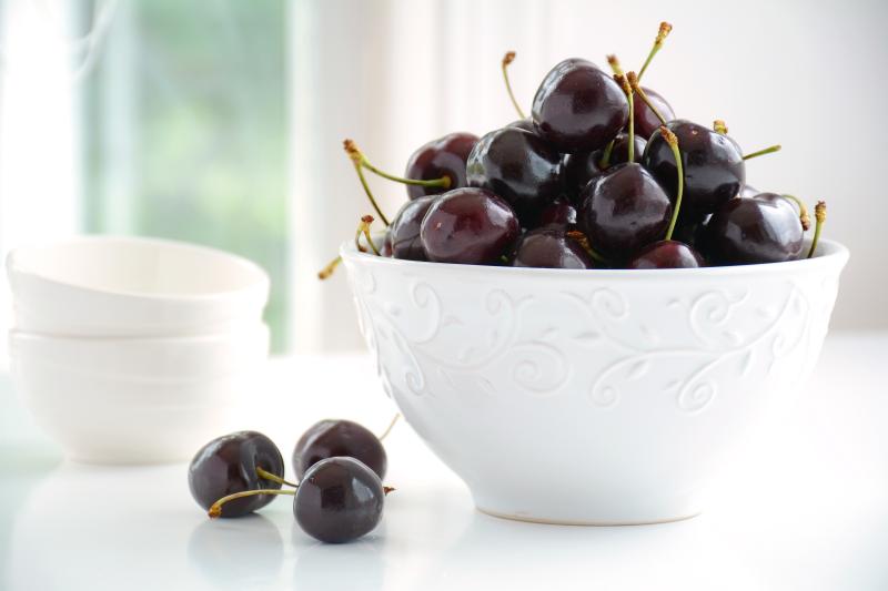 Dark Lapins cherries in a white bowl on a counter
