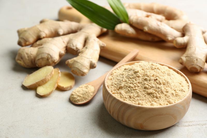 Fresh ginger roots and ginger in powder on a kitchen counter