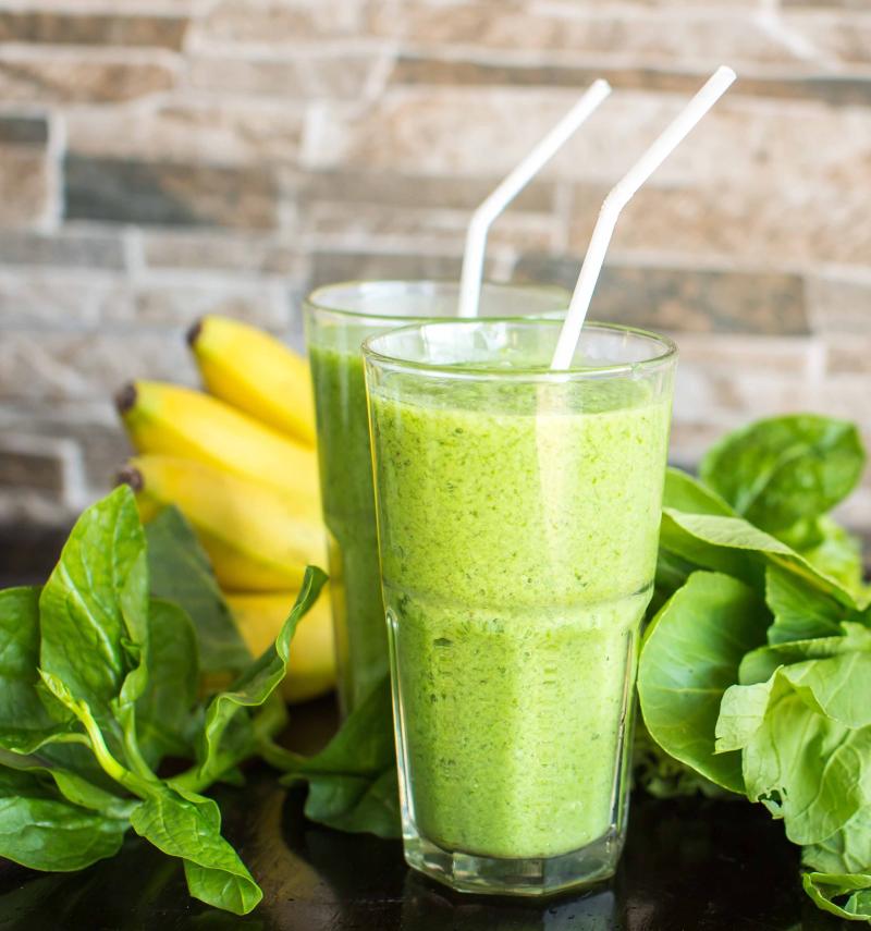 Fresh green smoothie with banana and spinach in two glasses